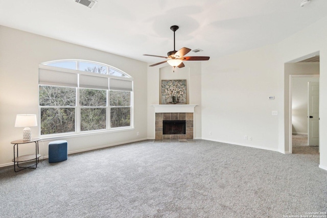 unfurnished living room featuring carpet flooring, a tiled fireplace, and ceiling fan