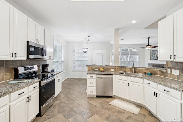 kitchen featuring decorative backsplash, sink, white cabinets, and appliances with stainless steel finishes