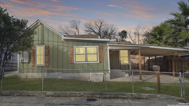 view of front of property with a lawn and a carport