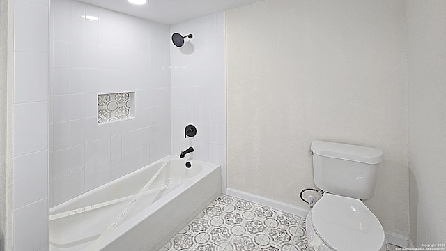 bathroom with tile patterned floors, tiled shower / bath combo, and toilet