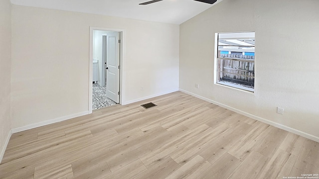 empty room featuring ceiling fan, light hardwood / wood-style flooring, and vaulted ceiling