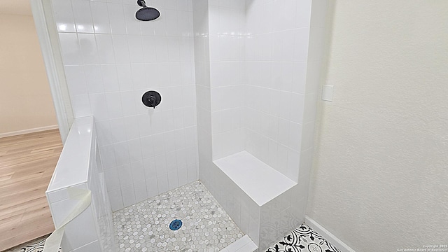 bathroom featuring hardwood / wood-style floors and tiled shower