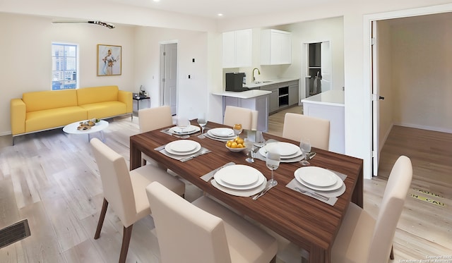 dining space featuring sink and light hardwood / wood-style flooring