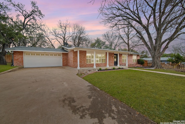 ranch-style home with a yard and a garage