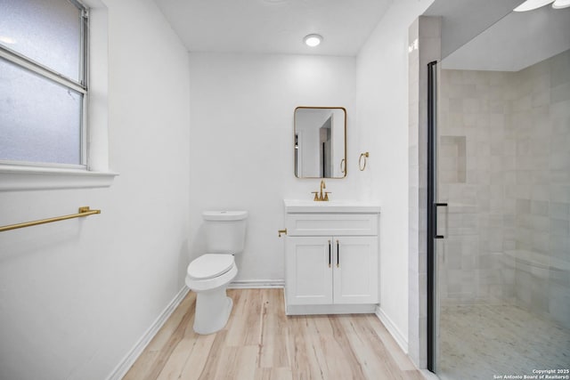 bathroom with wood-type flooring, vanity, toilet, and walk in shower