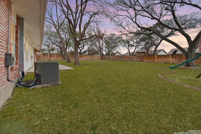 yard at dusk with central AC unit