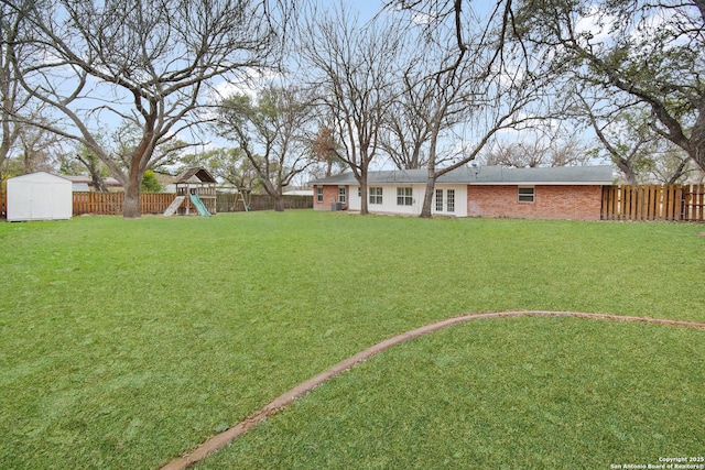 view of yard featuring a playground and a shed