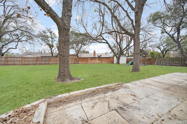 view of yard featuring a playground and a patio