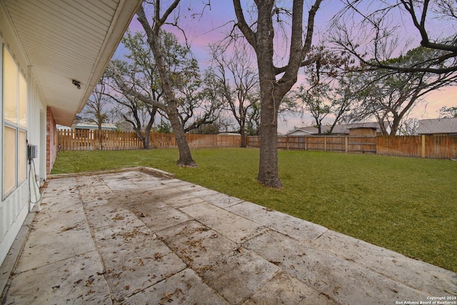 yard at dusk featuring a patio area