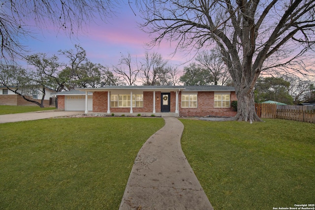 ranch-style home featuring a garage and a lawn