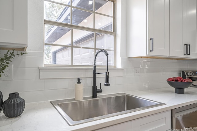 details with light stone countertops, tasteful backsplash, stainless steel dishwasher, sink, and white cabinets