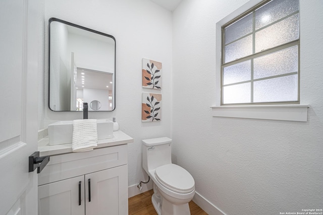 bathroom with hardwood / wood-style flooring, vanity, and toilet