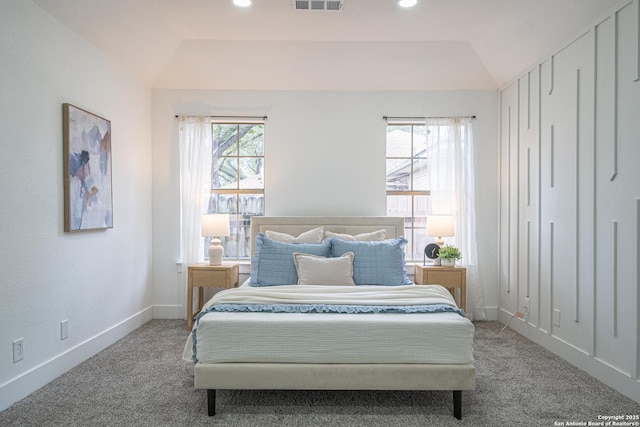 carpeted bedroom with vaulted ceiling and multiple windows