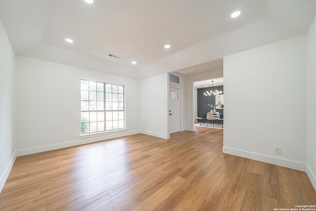 unfurnished room featuring light hardwood / wood-style flooring and a notable chandelier