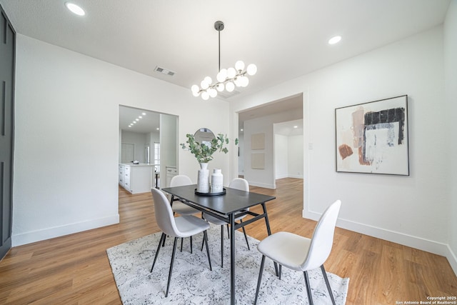 dining room with hardwood / wood-style flooring and a notable chandelier