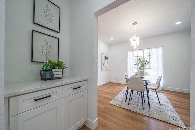 dining area with a notable chandelier and light wood-type flooring