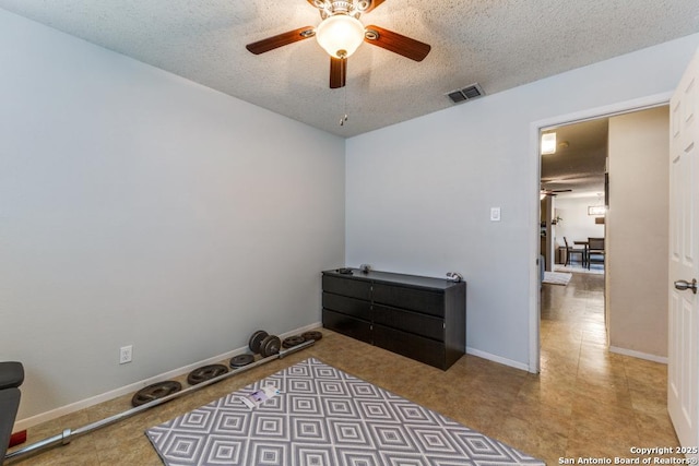 bedroom featuring ceiling fan and a textured ceiling