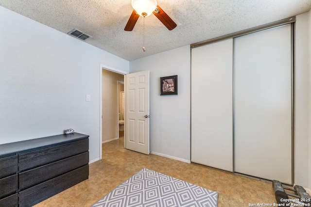 bedroom featuring ceiling fan, a closet, and a textured ceiling