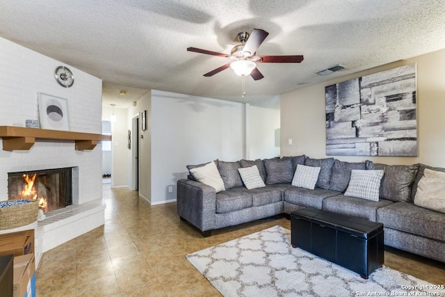 living room featuring a textured ceiling, a brick fireplace, and ceiling fan