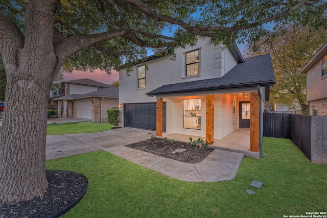 view of front of property with a porch, a garage, and a lawn