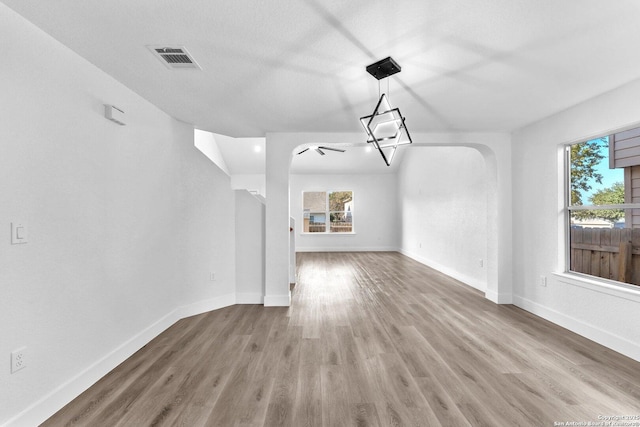 unfurnished living room featuring a textured ceiling and hardwood / wood-style flooring