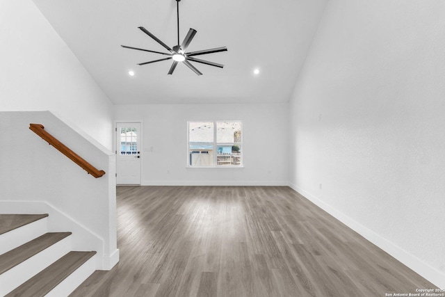 unfurnished living room featuring ceiling fan, vaulted ceiling, and hardwood / wood-style flooring