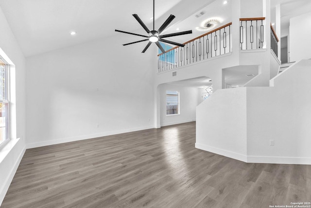 unfurnished living room with ceiling fan, hardwood / wood-style floors, and high vaulted ceiling