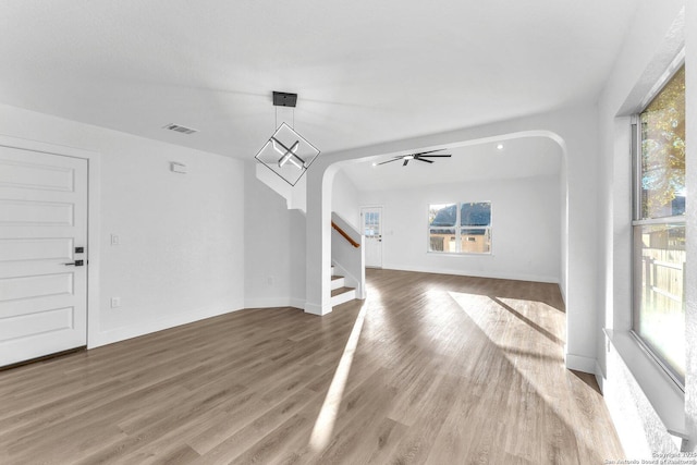 unfurnished living room with ceiling fan and wood-type flooring