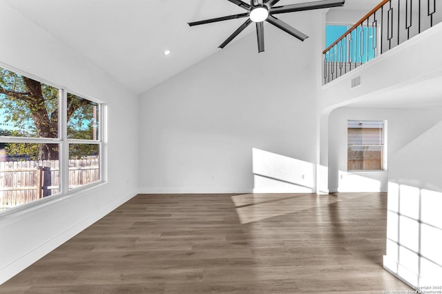 unfurnished living room with dark hardwood / wood-style floors, high vaulted ceiling, and ceiling fan