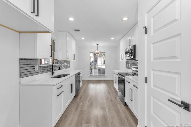 kitchen featuring appliances with stainless steel finishes, white cabinetry, and sink