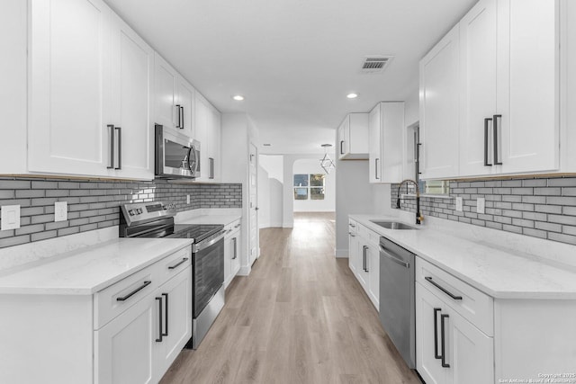 kitchen featuring white cabinets, sink, and appliances with stainless steel finishes