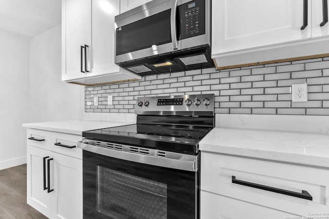 kitchen featuring light stone countertops, backsplash, stainless steel appliances, dark wood-type flooring, and white cabinets