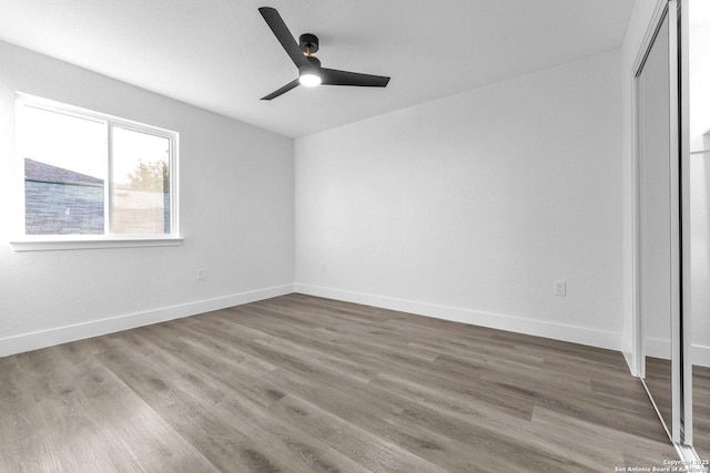 unfurnished bedroom featuring hardwood / wood-style floors, ceiling fan, and a closet