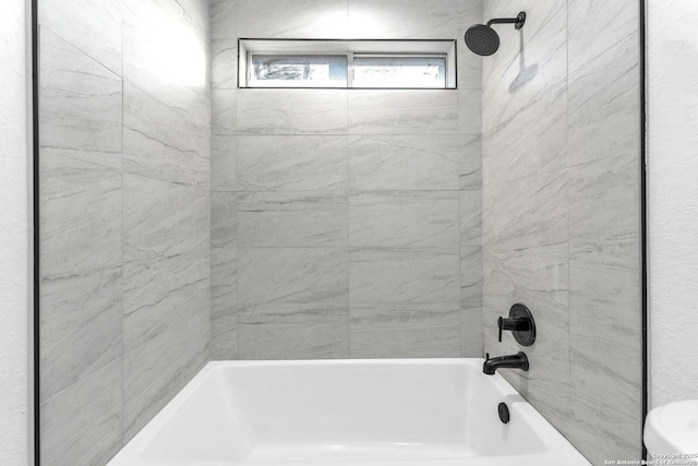 bathroom with tiled shower / bath combo