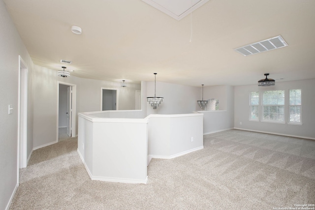 interior space with ceiling fan, light colored carpet, pendant lighting, and a kitchen island