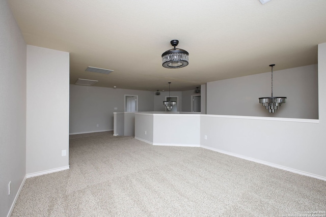 carpeted spare room with a chandelier