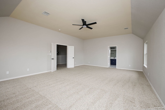 carpeted spare room with ceiling fan and vaulted ceiling