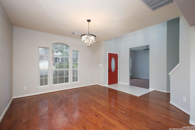 entrance foyer with light hardwood / wood-style flooring and a chandelier