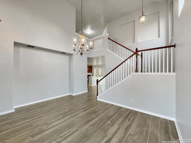 interior space featuring hardwood / wood-style flooring, a notable chandelier, and a high ceiling