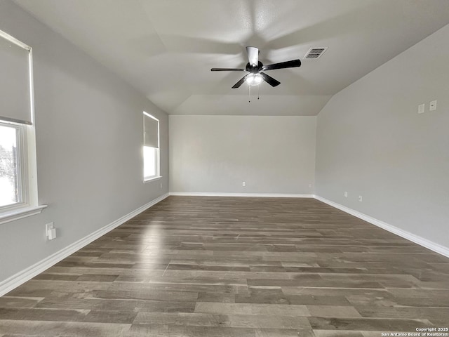 empty room featuring a healthy amount of sunlight, ceiling fan, and lofted ceiling