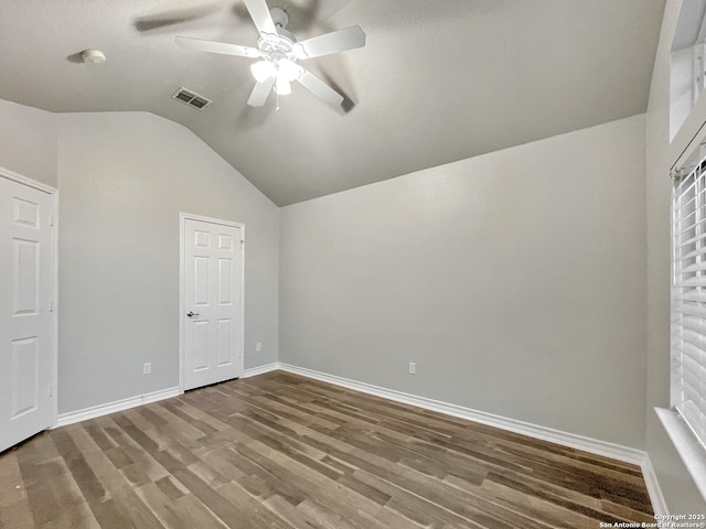 unfurnished bedroom featuring ceiling fan, wood-type flooring, and vaulted ceiling