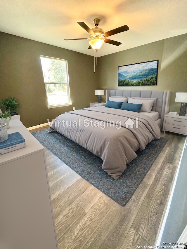 bedroom with ceiling fan and hardwood / wood-style flooring