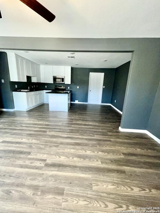 kitchen with white cabinets, light wood-type flooring, stainless steel appliances, and a kitchen island