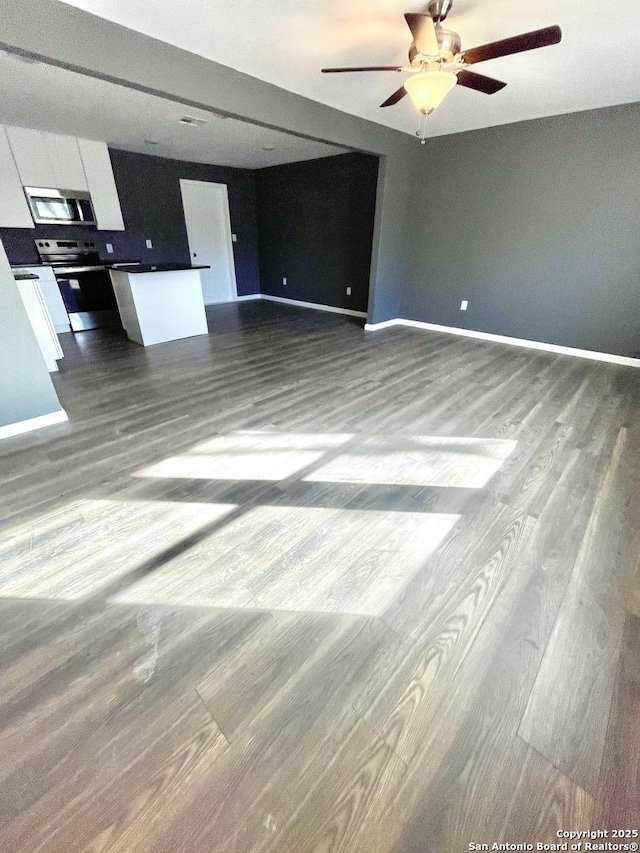 unfurnished living room featuring wood-type flooring and ceiling fan