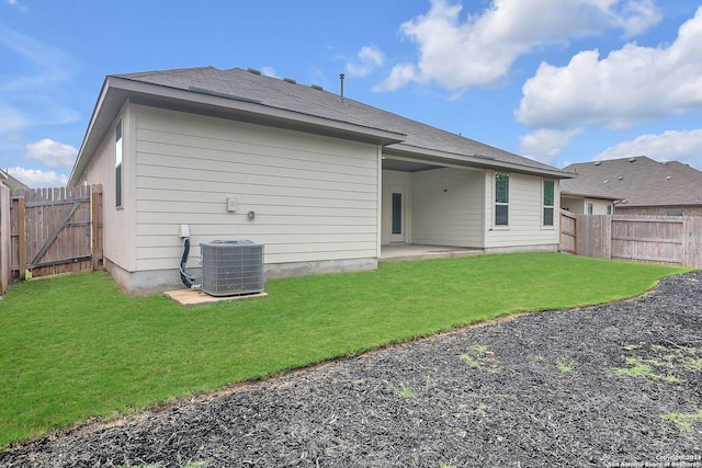 rear view of property with a yard, a patio, and central AC unit