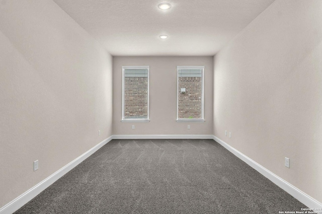 carpeted empty room with a textured ceiling