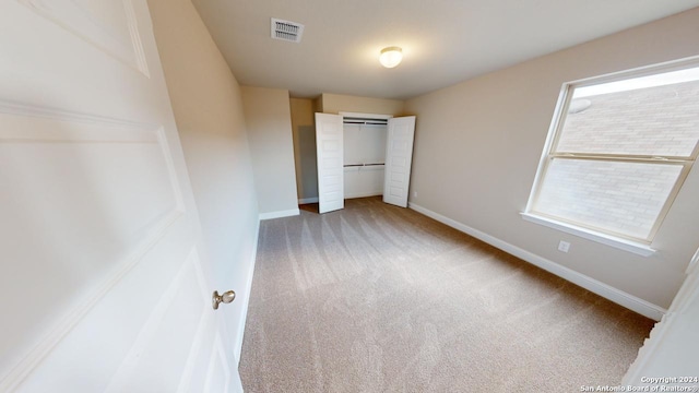 unfurnished bedroom with a closet and carpet