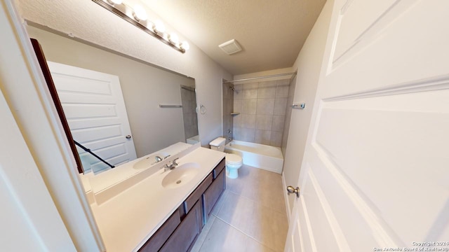 full bathroom with a textured ceiling, vanity, toilet, and tiled shower / bath combo