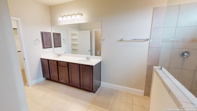 bathroom featuring tile patterned flooring, vanity, and tiled shower