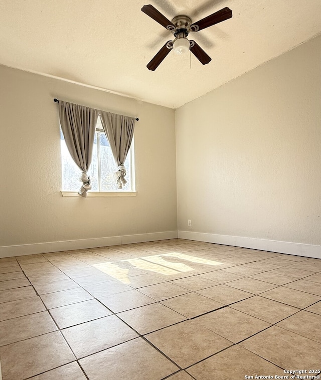 tiled spare room with ceiling fan